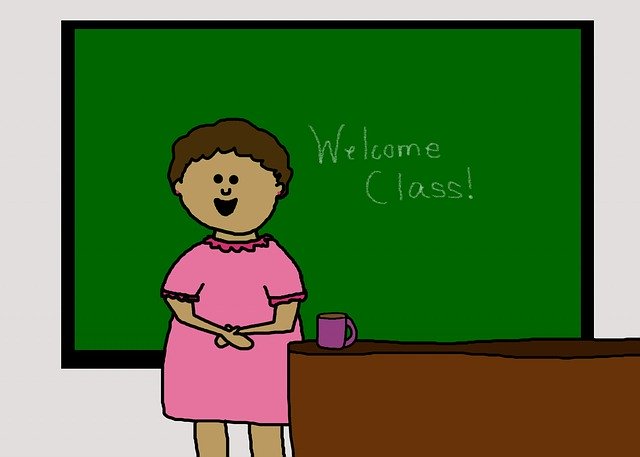 黒板の前に立って授業をする女の先生